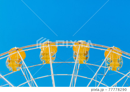 Sightseeing open ferris wheel in the amusement park on blue sky background 77778290