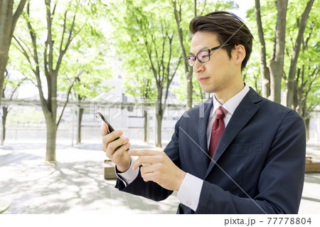 スマートフォンを使うビジネスマン 77778804