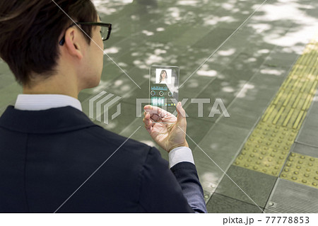 次世代スマートフォン(イメージ)を使うビジネスマン 次世代スマートフォン(イメージ)を使うビジネスマン 77778853