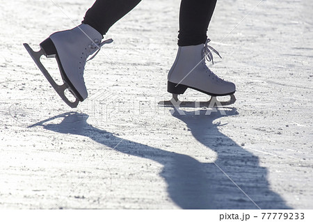 legs of a girl ice skating on an ice rink. hobbies and leisure. winter sports 77779233