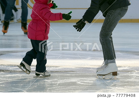 little girl with mother skate on the rink. 77779408