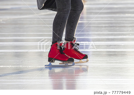 feet in red skates on an ice rink. hobbies and leisure. winter sports feet in red skates on an ice rink. hobbies and leisure. winter sports 77779449