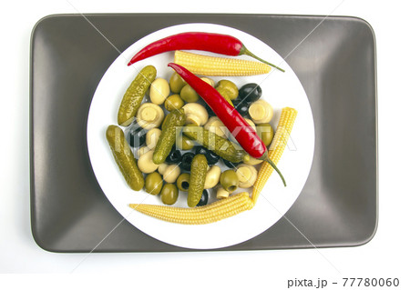 Olives, pickled cucumber, pepper, mushrooms and corn in a salad on a plate. 77780060