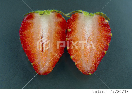 half of a strawberry on a green background half of a strawberry on a green background 77780713
