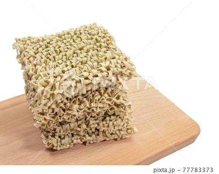 Spinach noodle, a close up of Taiwanese dried noodles fast food on wooden board isolated on white background. Spinach noodle, a close up of Taiwanese dried noodles fast food on wooden board isolated on white background. 77783373