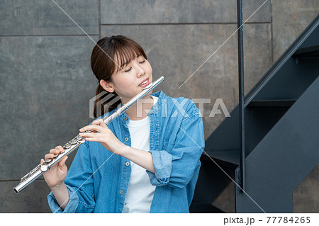 フルートを吹くカジュアルな女性の写真素材 [77784265] - PIXTA