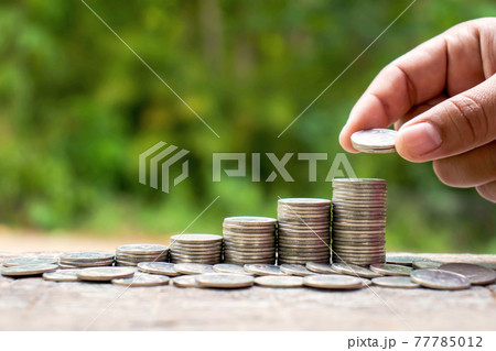 The hands of investors holding coins placed on gold coins at a level different from financial concepts Saving money and investing. The hands of investors holding coins placed on gold coins at a level different from financial concepts Saving money and investing. 77785012