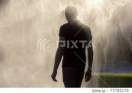 man walks in a thick fog of water drops man walks in a thick fog of water drops 77785279