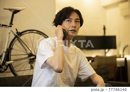 スマホを使う男性 77786140