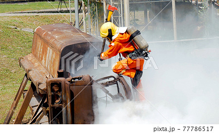 Firefighter fighting with flame using fire hose chemical water foam spray engine. Fireman wear hard hat, body safe suit uniform for protection. Rescue training in fire fighting extinguisher Firefighter fighting with flame using fire hose chemical water foam spray engine. Fireman wear hard hat, body safe suit uniform for protection. Rescue training in fire fighting extinguisher 77786517