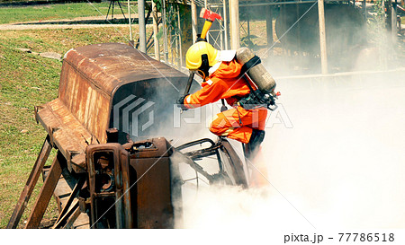 Firefighter fighting with flame using fire hose chemical water foam spray engine. Fireman wear hard hat, body safe suit uniform for protection. Rescue training in fire fighting extinguisher Firefighter fighting with flame using fire hose chemical water foam spray engine. Fireman wear hard hat, body safe suit uniform for protection. Rescue training in fire fighting extinguisher 77786518
