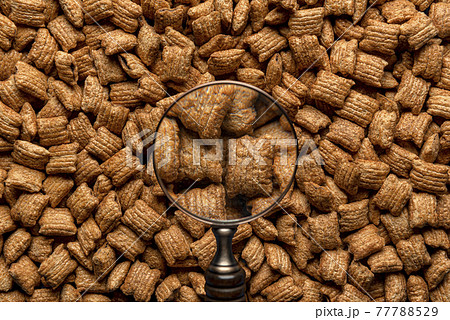 Cereal squares with chocolate filling through a magnifier. Caramel cereals, full-frame 77788529
