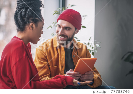 Young man and a woman talking and looking interested 77788746