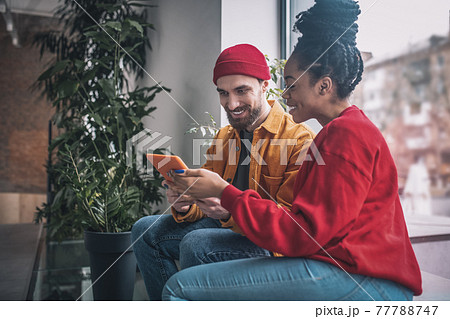 Young man and a woman talking and looking interested 77788747
