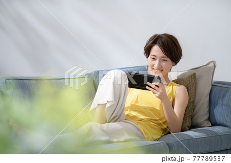 ミドル女性　ソファー　ゲーム 77789537