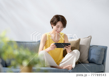 ミドル女性　ソファー　ゲーム 77789543