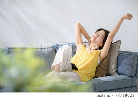 ミドル女性　ソファー　伸び 77789628