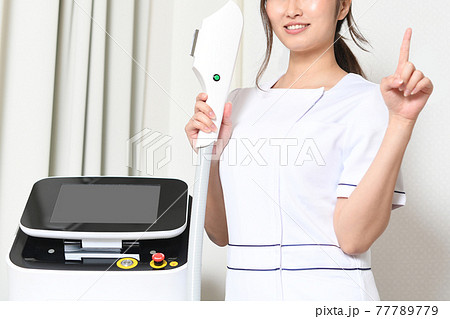 エステ器具と人差し指を立てるエステティシャンのイメージ 77789779