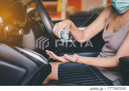 Woman using hand sanitizer gel before driving a car,Preventive measures against coronavirus,Covid-19 pandemic Woman using hand sanitizer gel before driving a car,Preventive measures against coronavirus,Covid-19 pandemic 77790500