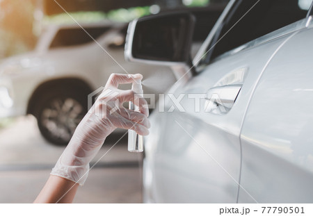 Woman hands spraying alcohol on car door handle,Preventive measures against coronavirus,Covid-19 pandemic Woman hands spraying alcohol on car door handle,Preventive measures against coronavirus,Covid-19 pandemic 77790501