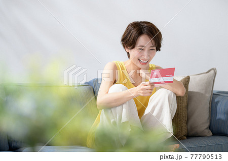 ミドル女性　通帳　笑顔　お金 77790513