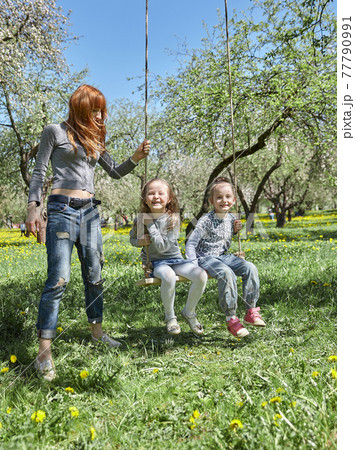 mom swings her kids on the garden swing mom swings her kids on the garden swing 77790991