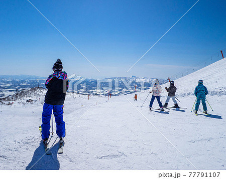 春先の晴れたゲレンデでスキーを楽しむ人達 (ニセコ、北海道) 77791107