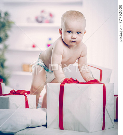 one year old cute baby playing with shopping in boxes on the sofa 77792009
