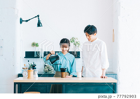 キッチンでコーヒーを入れる夫婦 キッチンでコーヒーを入れる夫婦 77792903