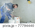 The worker mixes the solution in the bucket 77794440