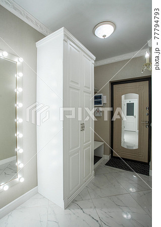 White hall with white wooden cabinet, door and marble tiles floor, interior design White hall with white wooden cabinet, door and marble tiles floor, interior design 77794793