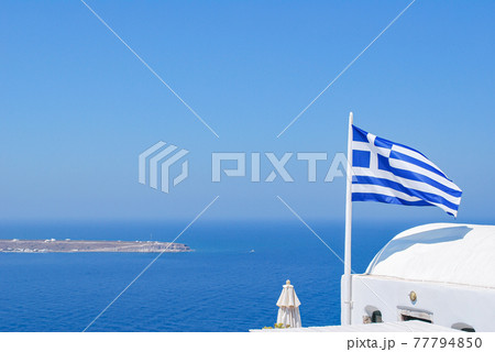 サントリーニ島からのギリシャ国旗とエーゲ海 77794850