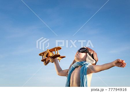 Happy child with airplane playing outdoor in summer Happy child with airplane playing outdoor in summer 77794916