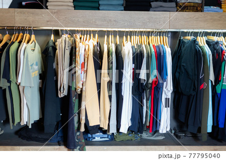 Interior of male clothing store with clothes on hangers and shelves 77795040