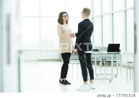 welcoming handshake of a Manager and the customer in the office welcoming handshake of a Manager and the customer in the office 77795328