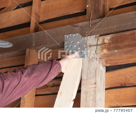 建築現場で働く大工　ヘキサプレート取り付け 77795407