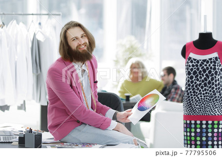 portrait of a clothing designer sitting on a Desk in the Studio portrait of a clothing designer sitting on a Desk in the Studio 77795506