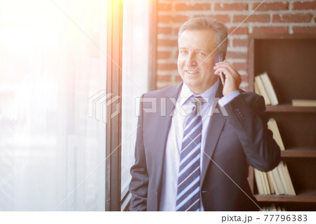 smiling business men talking on the phone 77796383