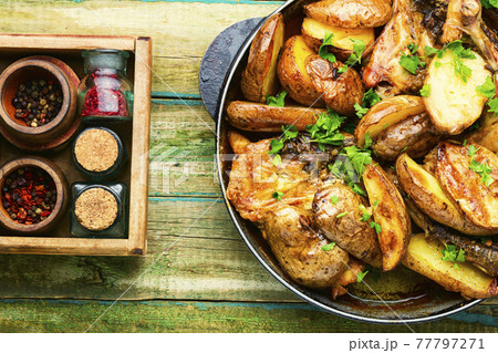 Chicken baked with potatoes in a iron cast pan 77797271