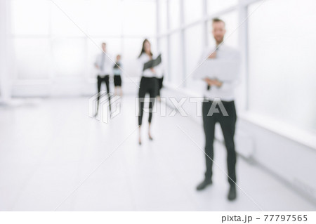 blurred image of employees standing in the office lobby 77797565