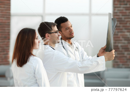 group of medical doctors discussing the patient's x-ray. group of medical doctors discussing the patient's x-ray. 77797624