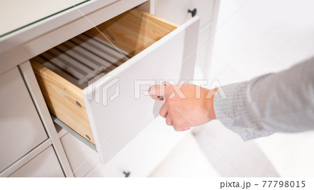Male hand opening drawer on wooden cabinet Male hand opening drawer on wooden cabinet 77798015
