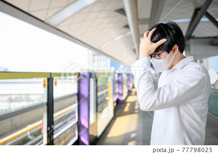 Asian man wearing mask at skytrain station Asian man wearing mask at skytrain station 77798025