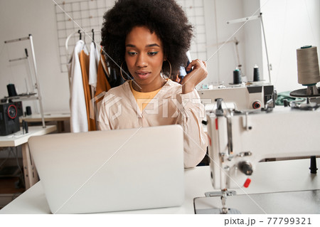 Woman looking attentively at the laptop screen while creating new collection Woman looking attentively at the laptop screen while creating new collection 77799321