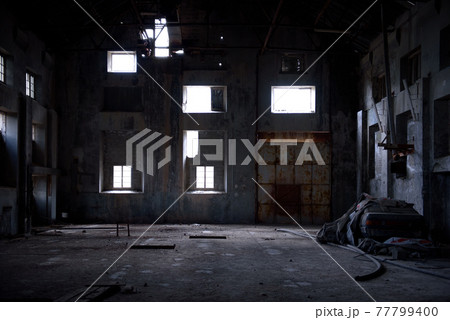 Abandoned warehouse interior with concrete walls, rusty gate and light falling through broken windows. Abandoned warehouse interior with concrete walls, rusty gate and light falling through broken windows. 77799400