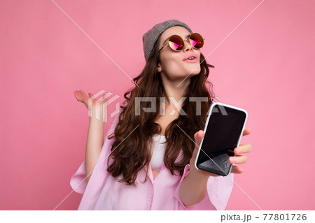 Positive attractive young brunette female person wearing stylish pink shirt grey hat and colourful 77801726