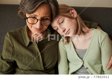 Girl bonding to her senior grandmother and watching something at the laptop 77802011