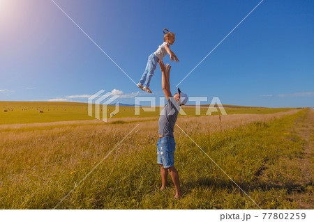 Harvest: ripe wheat grows in the field. Golden grainthe man throws the child up Harvest: ripe wheat grows in the field. Golden grainthe man throws the child up 77802259