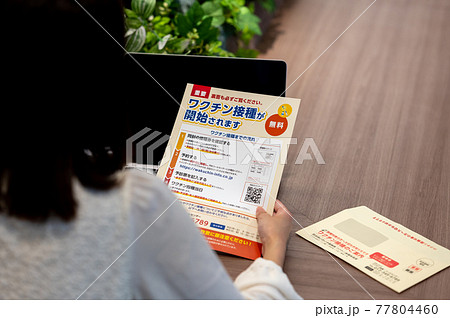 ワクチン接種のお知らせをみる女性のイメージ ワクチン接種のお知らせをみる女性のイメージ 77804460