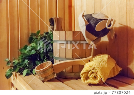 Interior details Finnish sauna steam room bathhouse with traditional sauna accessories basin birch broom scoop felt hat towel Interior details Finnish sauna steam room bathhouse with traditional sauna accessories basin birch broom scoop felt hat towel 77807024